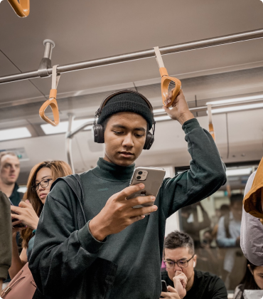 Young man holding a mobile phone while on a train