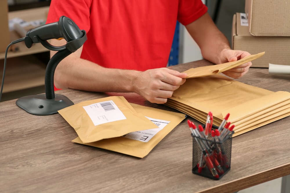 Post office worker with adhesive paper bags